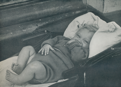 716630 Afbeelding van een baby in een kinderwagen, vermoedelijk in de Jordaan te Amsterdam.